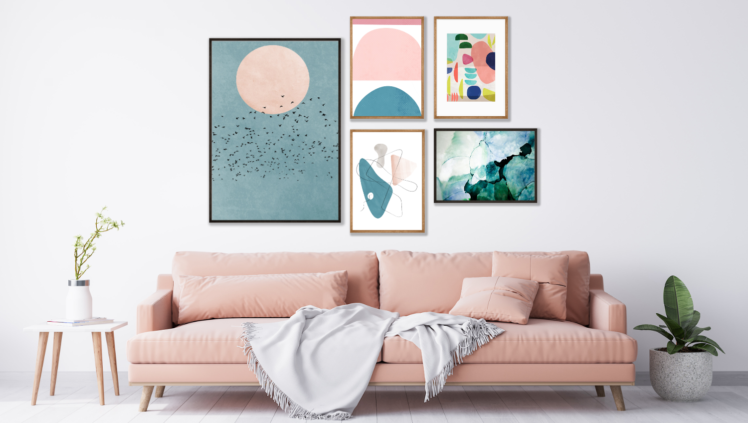 A selection of wall art prints and posters from Athena in a living room setting.  A collection of five abstract art prints in blues and pinks on the wall above a pink sofa